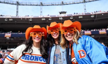 Denver Broncos fans dressed with colorful costumes and New Years Eve flair as they watch a game between the Denver Broncos and the Los Angeles Chargers at Empower Field at Mile High on December 31