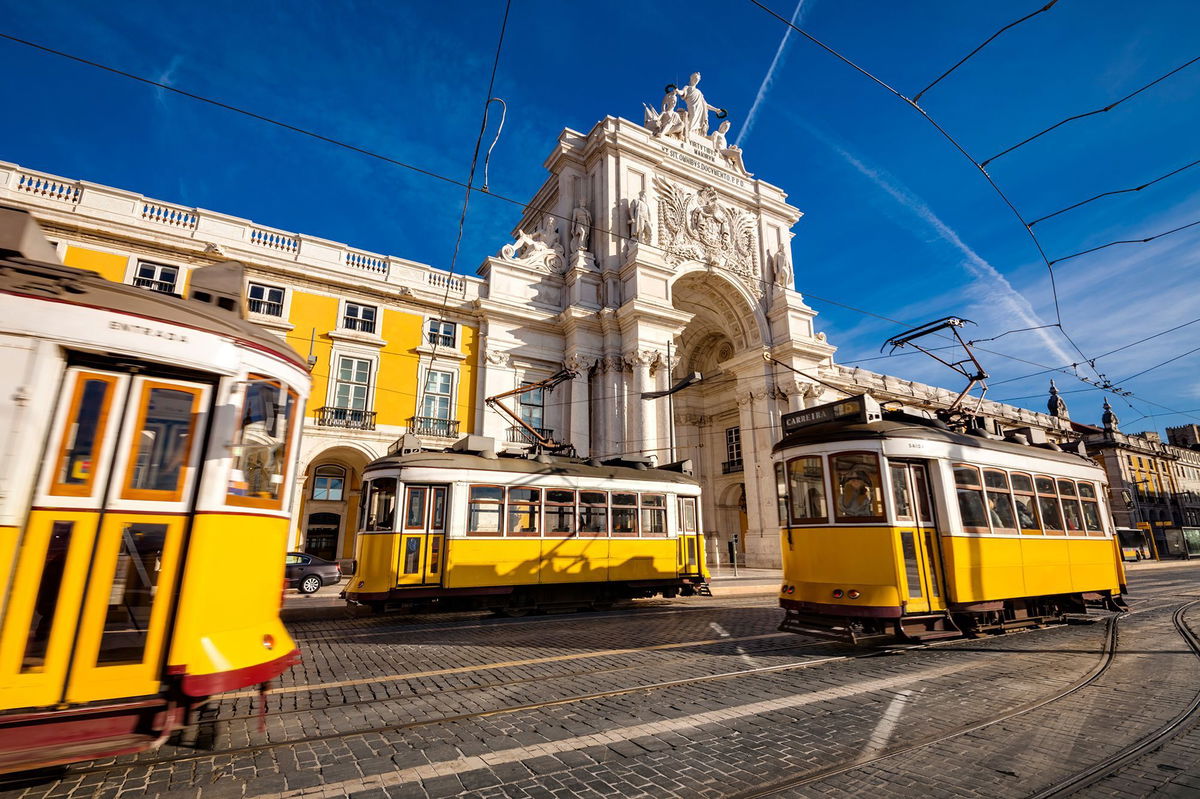 <i>Jorg Greuel/Stone RF/Getty Images via CNN Newsource</i><br/>Lisbon's traditional trams pass in front of the Rua Augusta Arch.