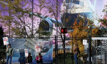 Boeing factory workers hold signs on the picket line outside the Boeing manufacturing facility in this October 24 file photo