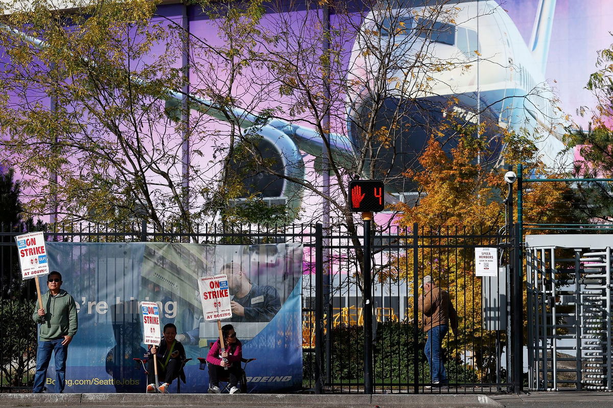 <i>Aaron M. Sprecher/AP via CNN Newsource</i><br/>Boeing factory workers hold signs on the picket line outside the Boeing manufacturing facility in this October 24 file photo