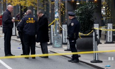 Police officers stand near the scene where the CEO of United Healthcare