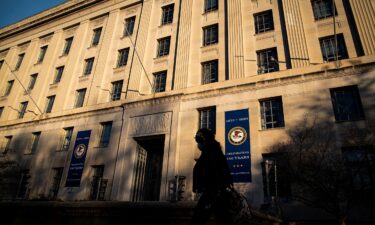 A woman walks past the US Department of Justice in Washington