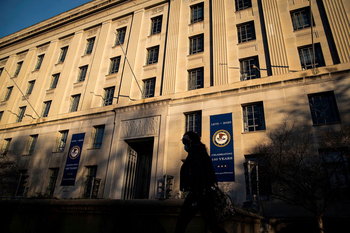 <i>Al Drago/Reuters via CNN Newsource</i><br/>A woman walks past the US Department of Justice in Washington