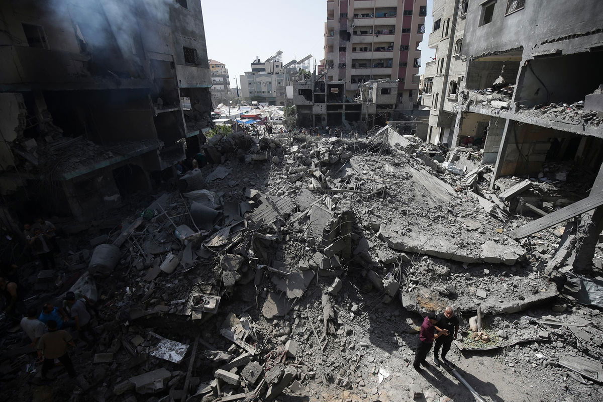 <i>Jehad Alshrafi/AP/File via CNN Newsource</i><br/>Palestinians look at the aftermath of an Israeli bombing in Nuseirat refugee camp in the Gaza Strip in June.