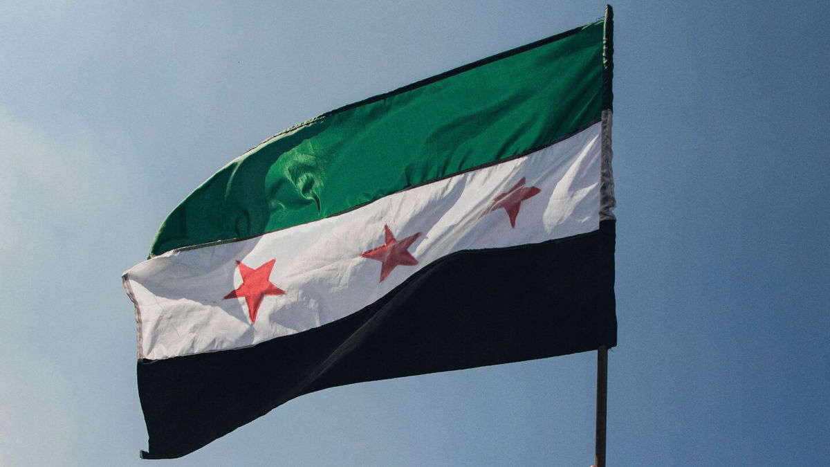 <i>Mohammed Nammoor/Middle East Images/AFP/Getty Images via CNN Newsource</i><br/>A Syrian opposition flag is waved in Damascus