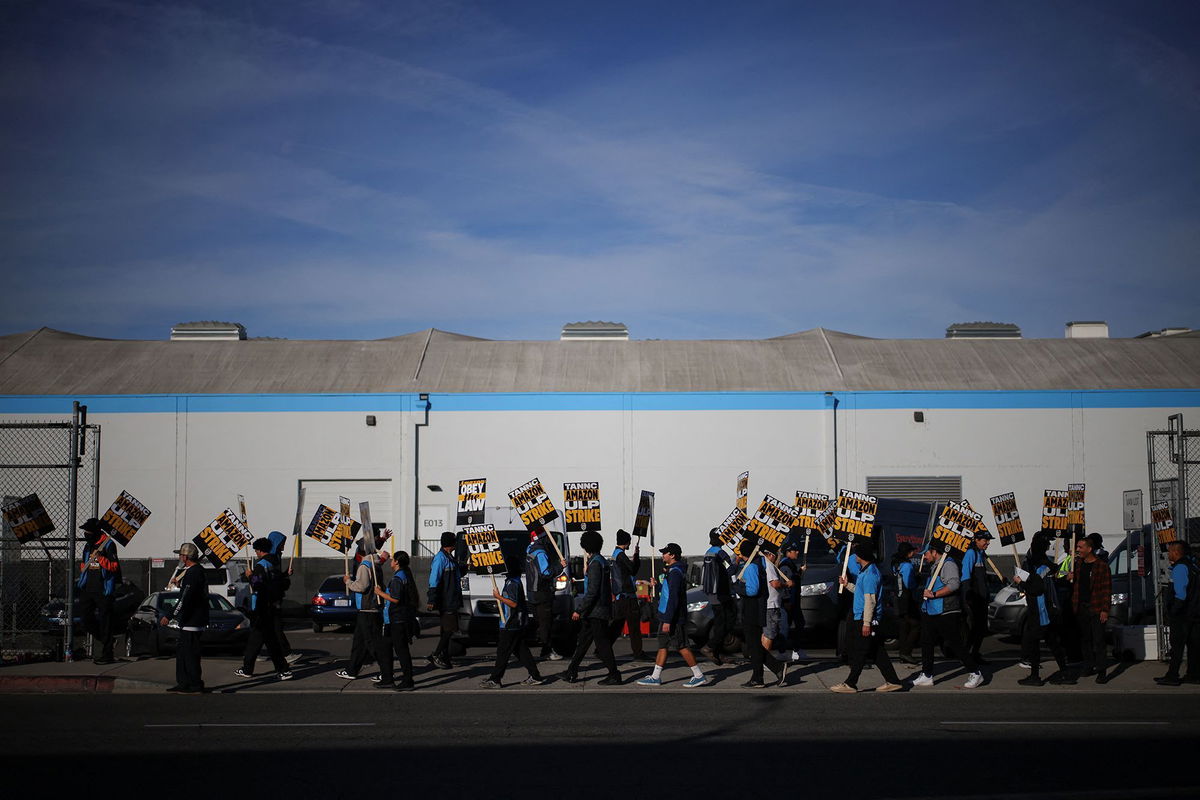 <i>Daniel Cole/Reuters via CNN Newsource</i><br/>Striking workers picket outside an Amazon warehouse in City of Industry