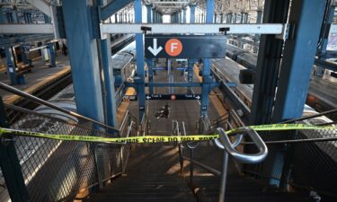 Police take security measures at the scene where a woman died after being lit on fire by a man aboard a subway train as she slept.