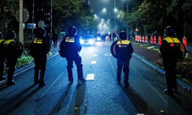 Police officers stand near a pro-Palestinian demonstration during a soccer match between Ajax Amsterdam and Maccabi Tel Aviv in Amsterdam