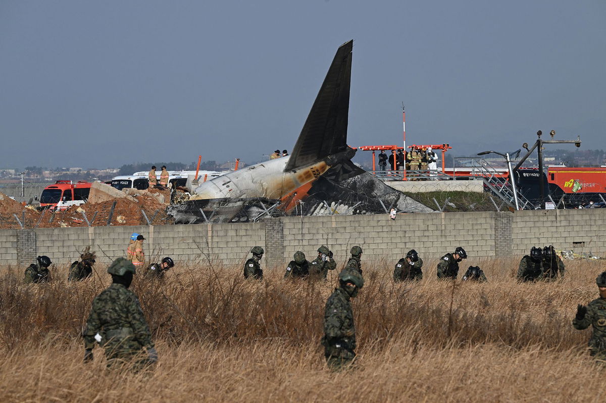 <i>Jung Yeon-Je/AFP/Getty Images via CNN Newsource</i><br/>South Korean soldiers search for missing passengers near the wreckage of a Jeju Air Boeing 737-800 aircraft after the plane crashed and burst into flames at Muan International Airport in South Jeolla Province.