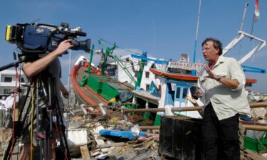 Aaron Brown of CNN broadcast from a on top Jembatan di Penayong bridge in Banda Aceh