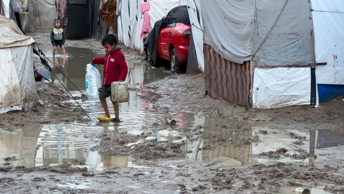 <i>Mohammad Al-Sawalhi/CNN via CNN Newsource</i><br/>A boy walks down a flooded road in between makeshift tents in Deir Al-Balah