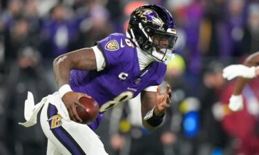 Baltimore Ravens quarterback Lamar Jackson runs with the ball against the Pittsburgh Steelers during the first half of an NFL wild-card playoff football game.