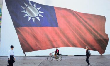 People walk past a Taiwanese flag in New Taipei City.