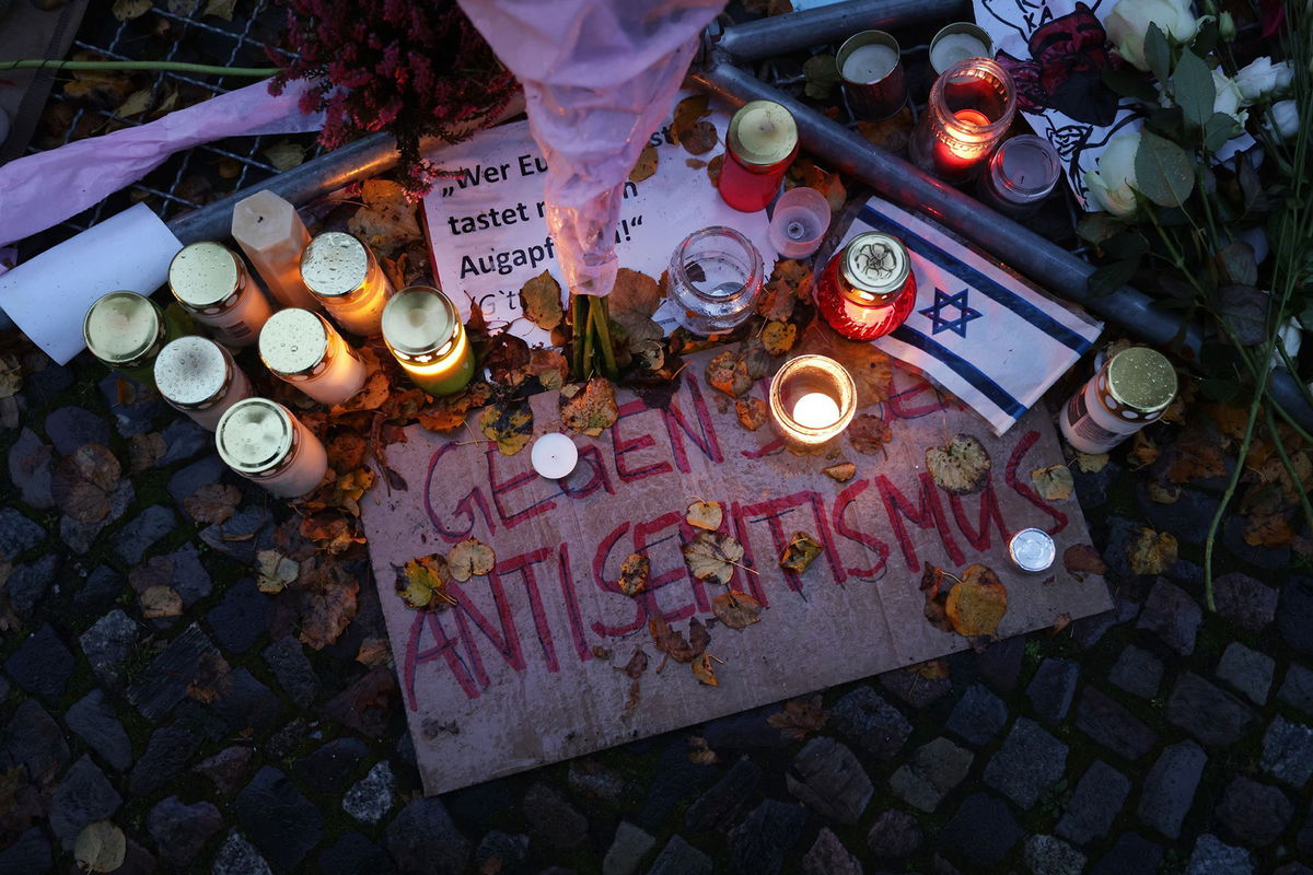 <i>Sean Gallup/Getty Images via CNN Newsource</i><br/>Candles left by participants stand over a sign that reads: 