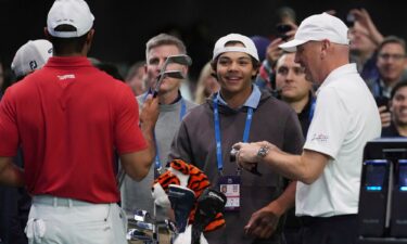 Charlie Woods watches his father Tiger warm up before his TGL debut.