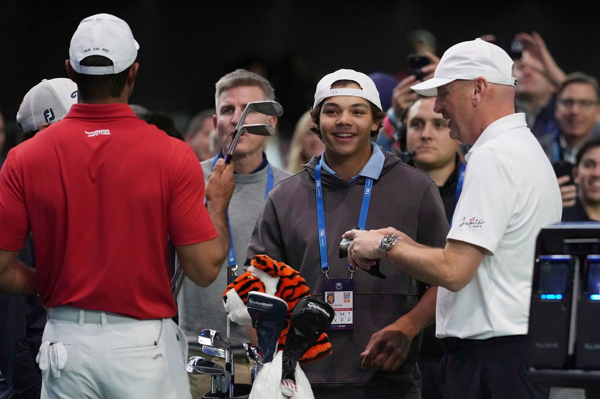 <i>Marta Lavandier/AP via CNN Newsource</i><br/>Charlie Woods watches his father Tiger warm up before his TGL debut.