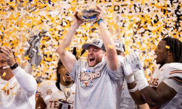 Texas quarterback Quinn Ewers raises the Peach Bowl trophy after defeating Arizona State in Atlanta.