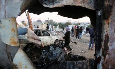 Palestinians survey the aftermath of an Israeli strike in Al-Mawasi