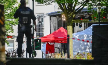 Police investigators stand at the site of yesterday's deadly stabbings that left three dead and eight injured in Solingen