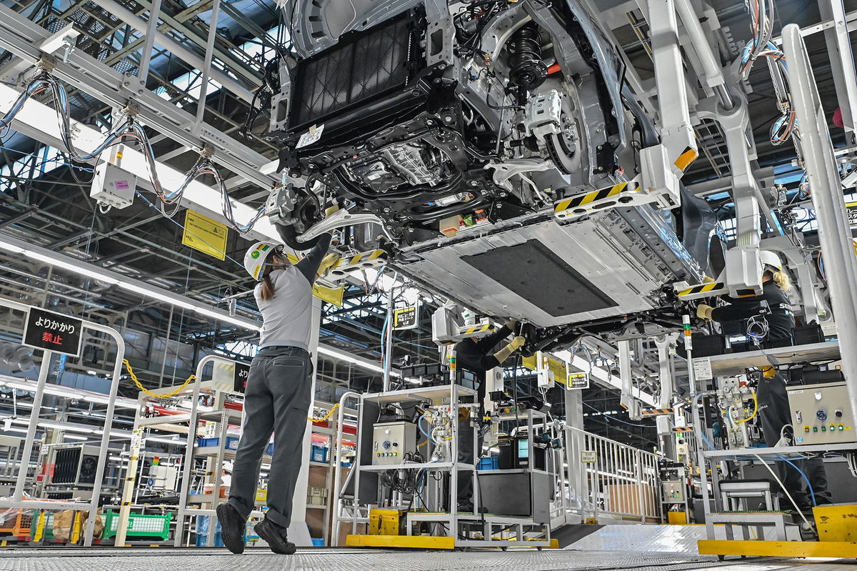 <i>Richard A. Brooks/AFP/Getty Images via CNN Newsource</i><br/>A worker checking a car on a Nissan production line.