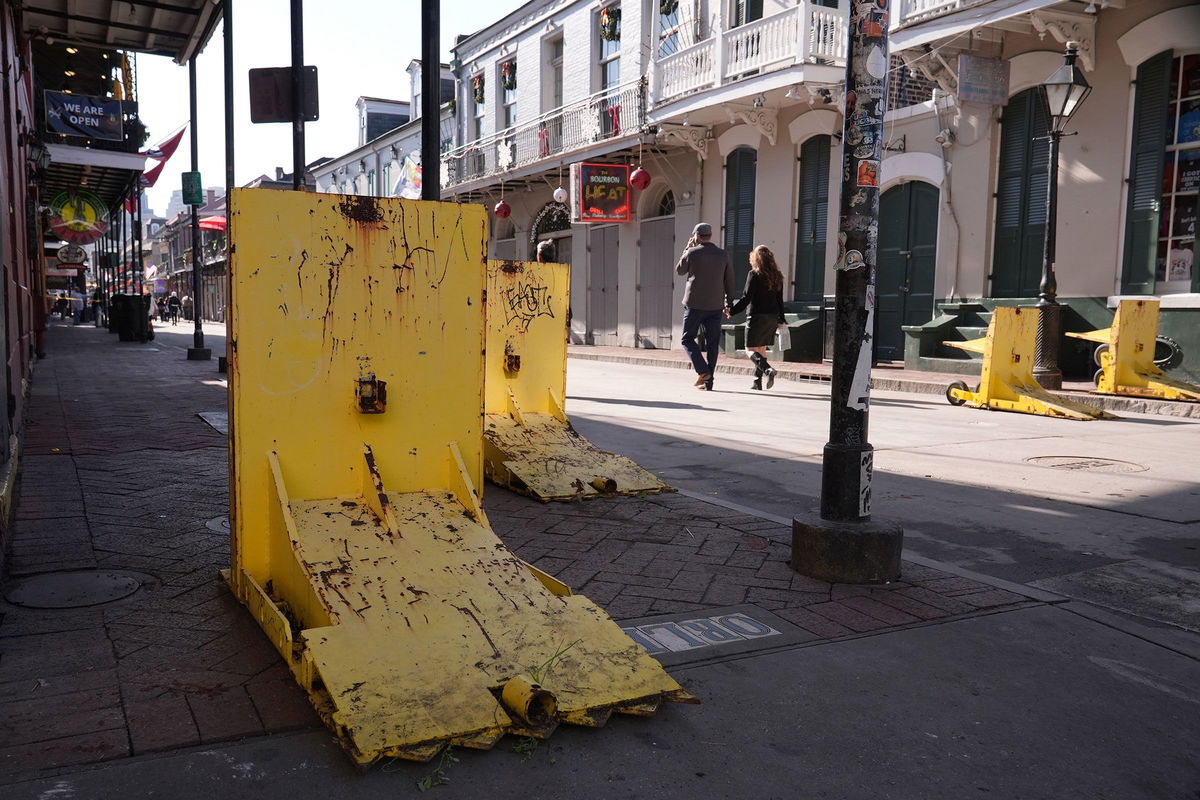 <i>George Walker IV/AP via CNN Newsource</i><br/>Tourist walk past temporary barriers on Bourbon Street on January 2.