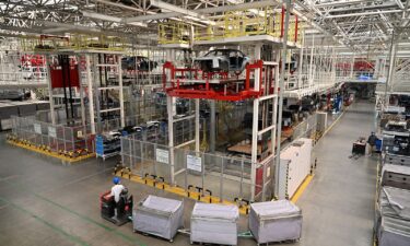 A worker transports parts to the assembly line of electric cars at a Leap Motors plant in Jinhua in east China's Zhejiang province on November 26