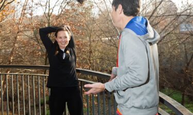 Madeline Holcombe stretches while David Allan explains that when it comes to warming up he's not a great role model.