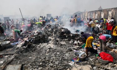 People try to salvage items after the fire at the Kantamanto market