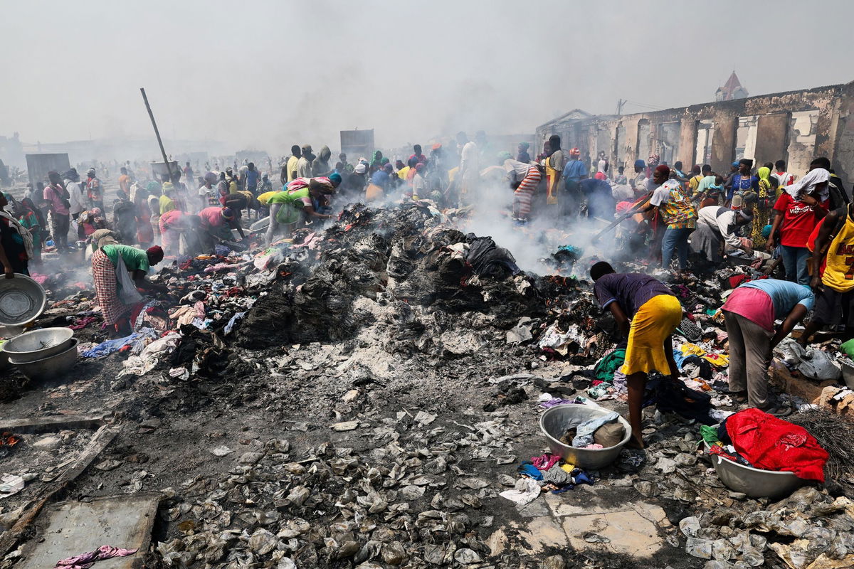 <i>Nipah Dennis/AFP/Getty Images via CNN Newsource</i><br/>People try to salvage items after the fire at the Kantamanto market