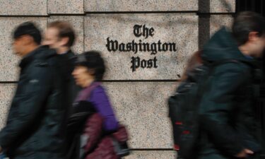 A file photo of people walking by The Washington Post. Pulitzer Prize-winning cartoonist Ann Telnaes announced Friday she had resigned after the newspaper refused to publish a satirical cartoon depicting billionaire Post owner Jeff Bezos on bended knee in front of President-elect Donald Trump.