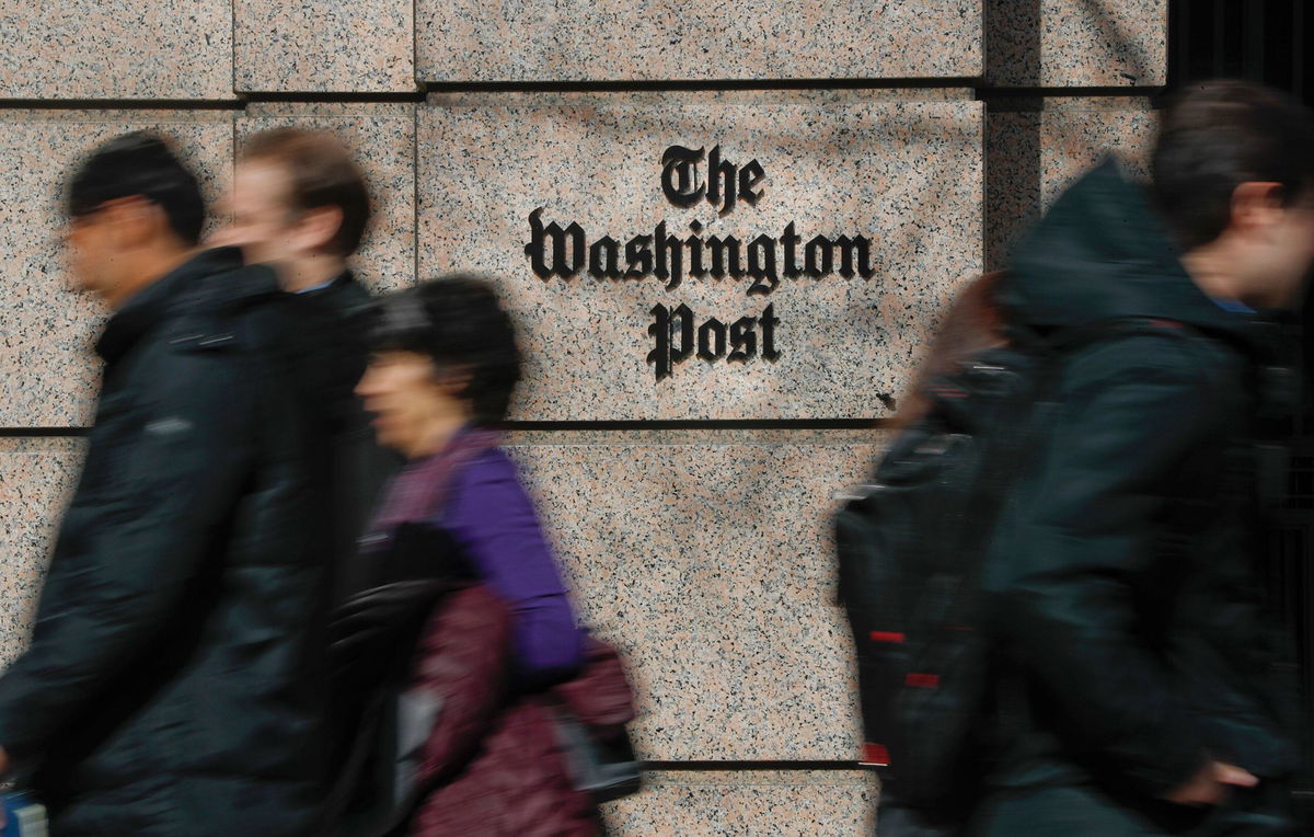 <i>Pablo Martinez Monsivais/AP via CNN Newsource</i><br/>A file photo of people walking by The Washington Post. Pulitzer Prize-winning cartoonist Ann Telnaes announced Friday she had resigned after the newspaper refused to publish a satirical cartoon depicting billionaire Post owner Jeff Bezos on bended knee in front of President-elect Donald Trump.