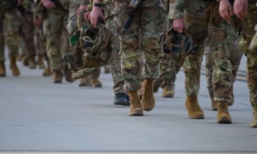 Soldiers walk across the tarmac to deploy to Poland in February 2022. Thousands of LGBTQ+ US military veterans who were discharged under the “don’t ask