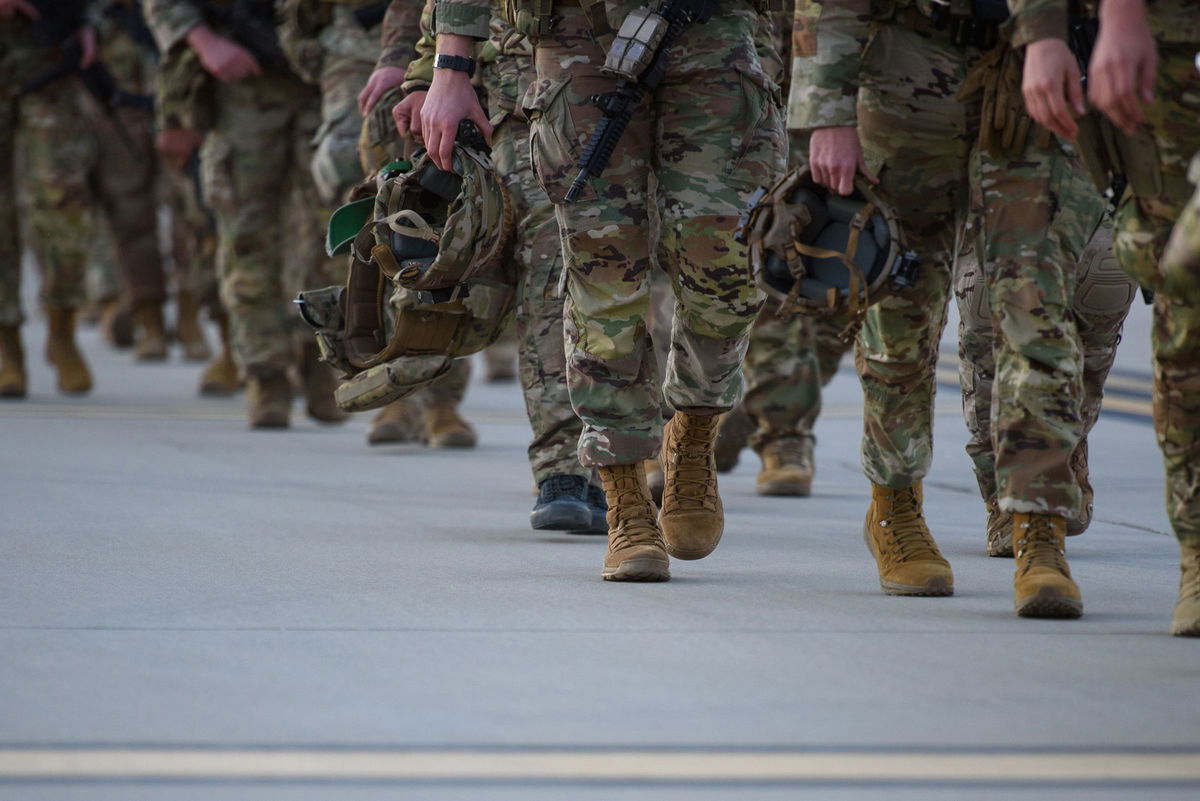 <i>Melissa Sue Gerrits/Getty Images via CNN Newsource</i><br/>Soldiers walk across the tarmac to deploy to Poland in February 2022. Thousands of LGBTQ+ US military veterans who were discharged under the “don’t ask