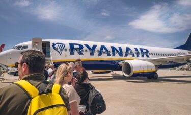 People wait to board a Ryanair plane heading to Carcassonne in France on the runway at Porto airport