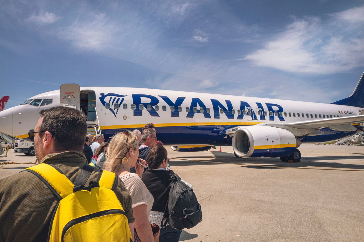 <i>Idriss Bigou-Gilles/Hans Lucas/AFP/Getty Images/File via CNN Newsource</i><br/>People wait to board a Ryanair plane heading to Carcassonne in France on the runway at Porto airport