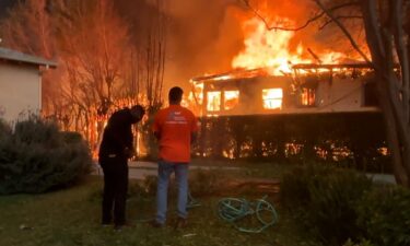 Volunteers try to douse Gail's home and yard to keep the flames at bay.