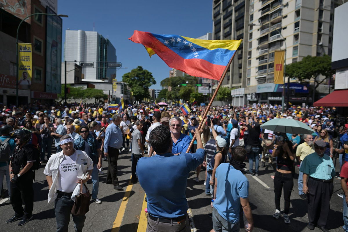 <i>Juan Barreto/AFP/Getty Images via CNN Newsource</i><br/>A demonstrator waves a Venezuelan flag at an opposition protest in Caracas on January 9.