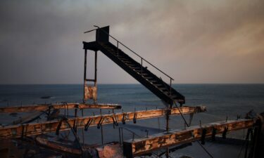 A staircase remains standing amid the ruins of a burnt structure along the Pacific Coast Highway in Malibu