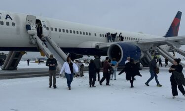 Passengers exit a Delta airplane at Hartsfield-Jackson Airport in Atlanta after an emergency on the runway on Friday