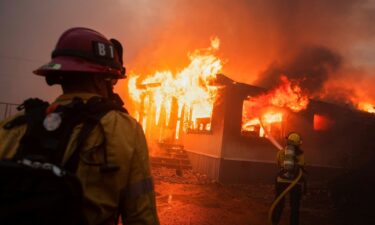 Firefighters work to extinguish the Palisades Fire during a windstorm on the west side of Los Angeles