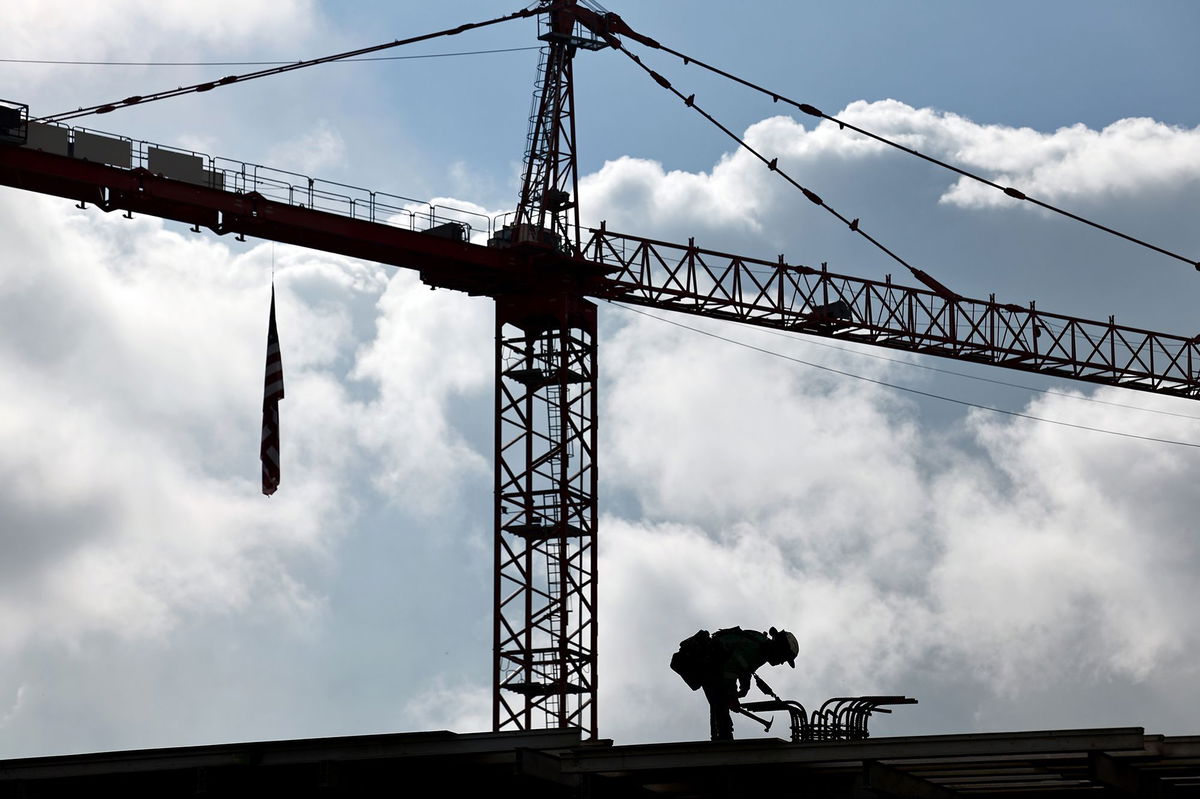 <i>Mario Tama/Getty Images via CNN Newsource</i><br/>A construction worker helps build a mixed-use apartment complex on January 25