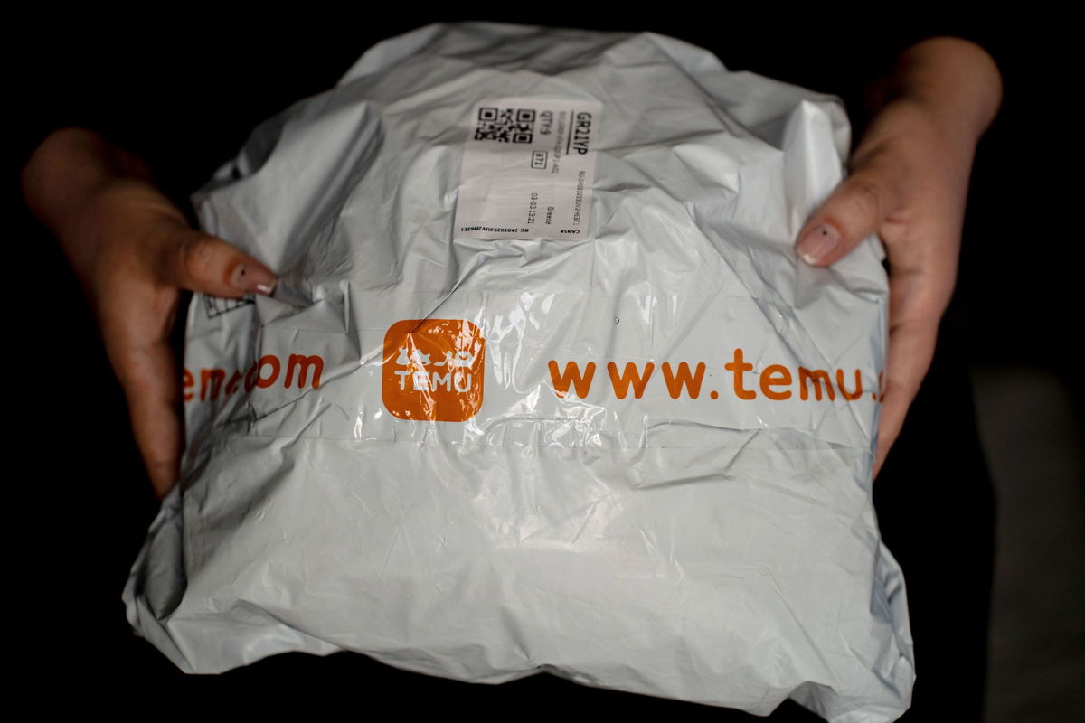 <i>NurPhoto/NurPhoto/Getty Images via CNN Newsource</i><br/>A person holds a package from Temu.