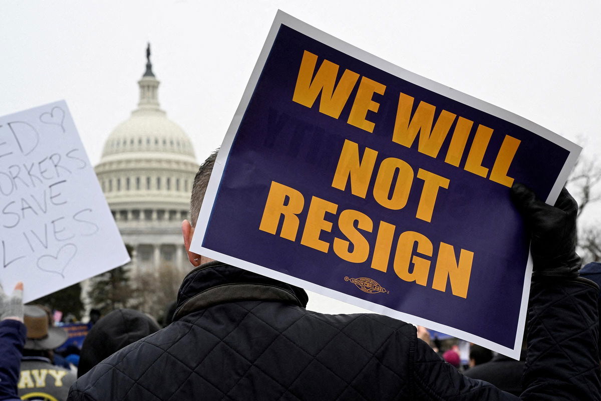 <i>Craig Hudson/Reuters/File via CNN Newsource</i><br/>A person displays a sign as labor union activists rally in support of federal workers during a protest