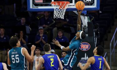 UNCW forward Sean Moore goes to the basket in the first half of the CAA championship.