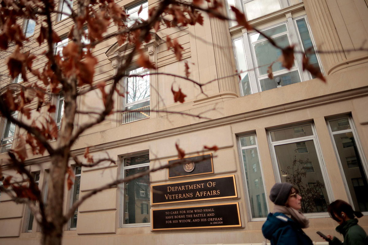 <i>Chip Somodevilla/Getty Images via CNN Newsource</i><br/>People walk past the Department of Veterans Affairs headquarters a block from the White House on March 6 in Washington