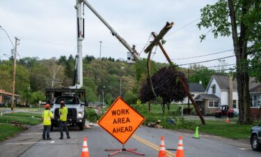 A crew works to remove a tree from a power pole in in Gnadenhutten