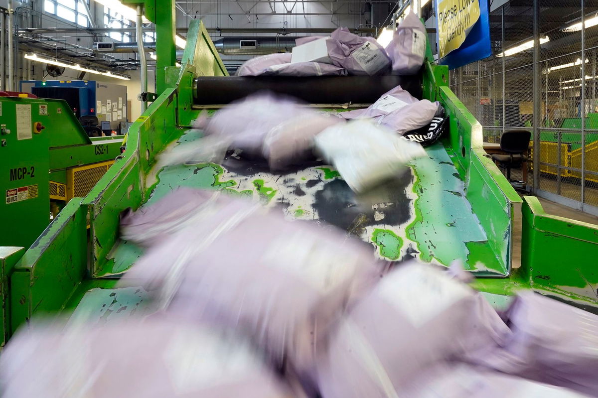 <i>Charles Rex Arbogast/AP via CNN Newsource</i><br/>Parcels slide down a ramp after being scanned at the US Customs and Border Protection overseas mail inspection facility at Chicago's O'Hare International Airport in February 2024.