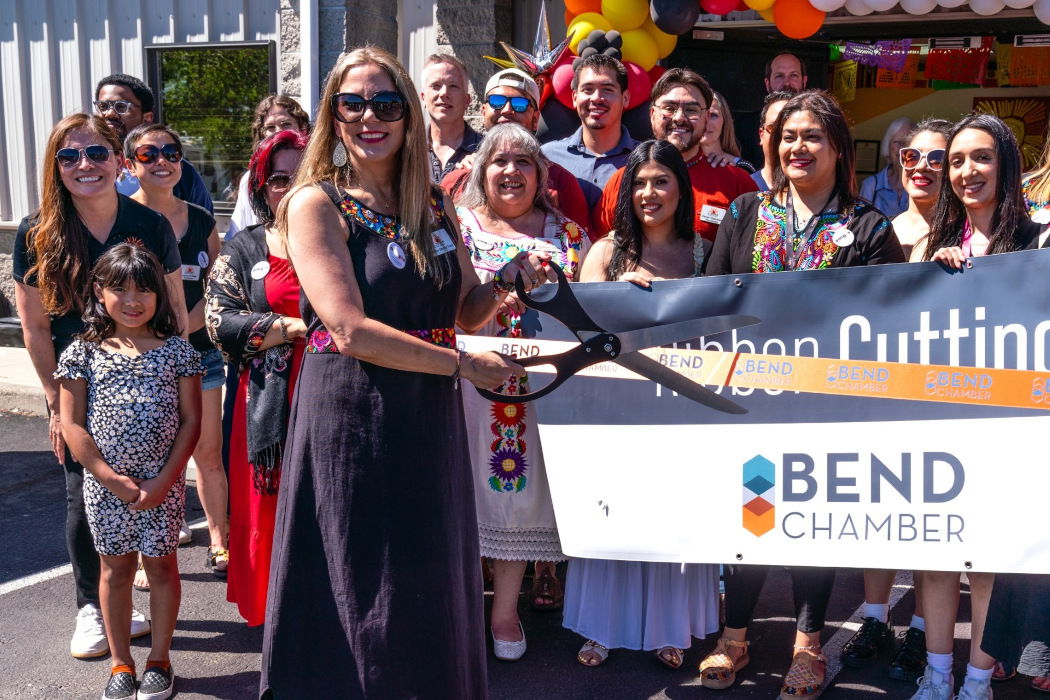 Catalina Sánchez Frank, Latino Community Association's executive director, cuts the ribbon to celebrate the organization’s purchase of the building it has called home since fall of 2021.