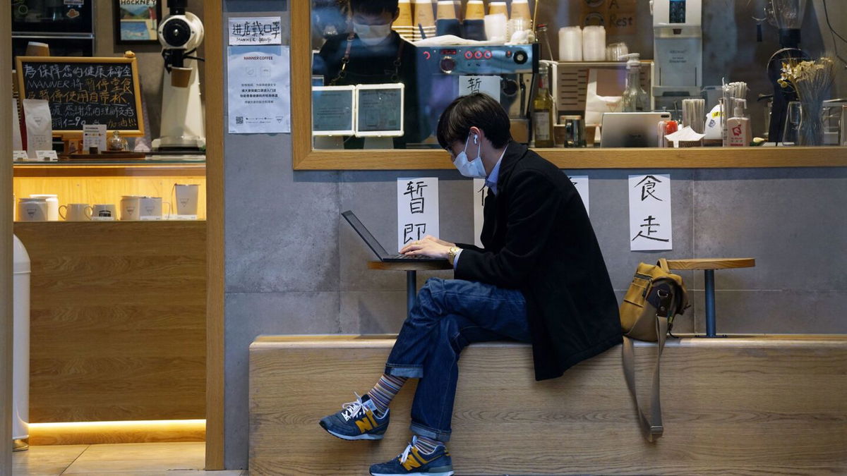 <i>Yu Ruwen/Future Publishing/Getty Images/File via CNN Newsource</i><br/>A man uses his laptop outside a coffee shop in Shanghai