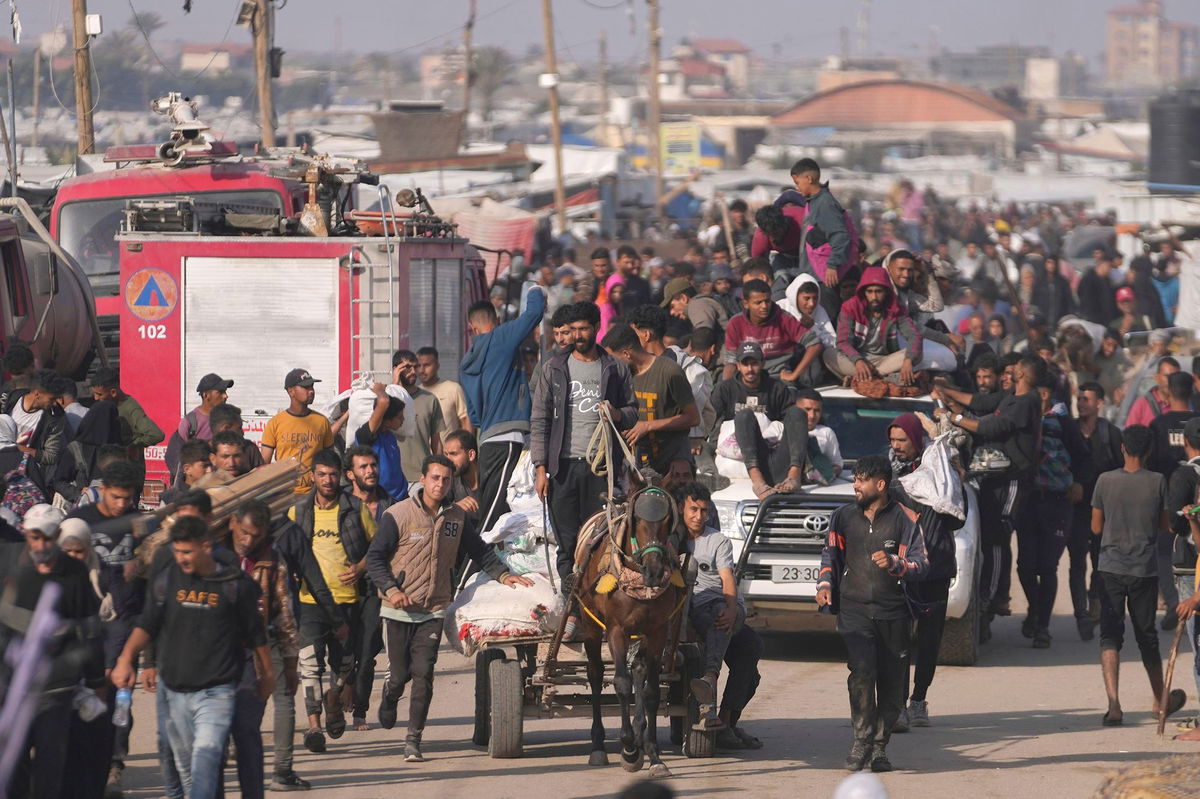 <i>Abdel Kareem Hana/AP via CNN Newsource</i><br/>Palestinians carry food packages from the US and Israeli-backed Gaza Humanitarian Foundation